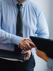 Financial adviser shaking hands after agreement with a client.